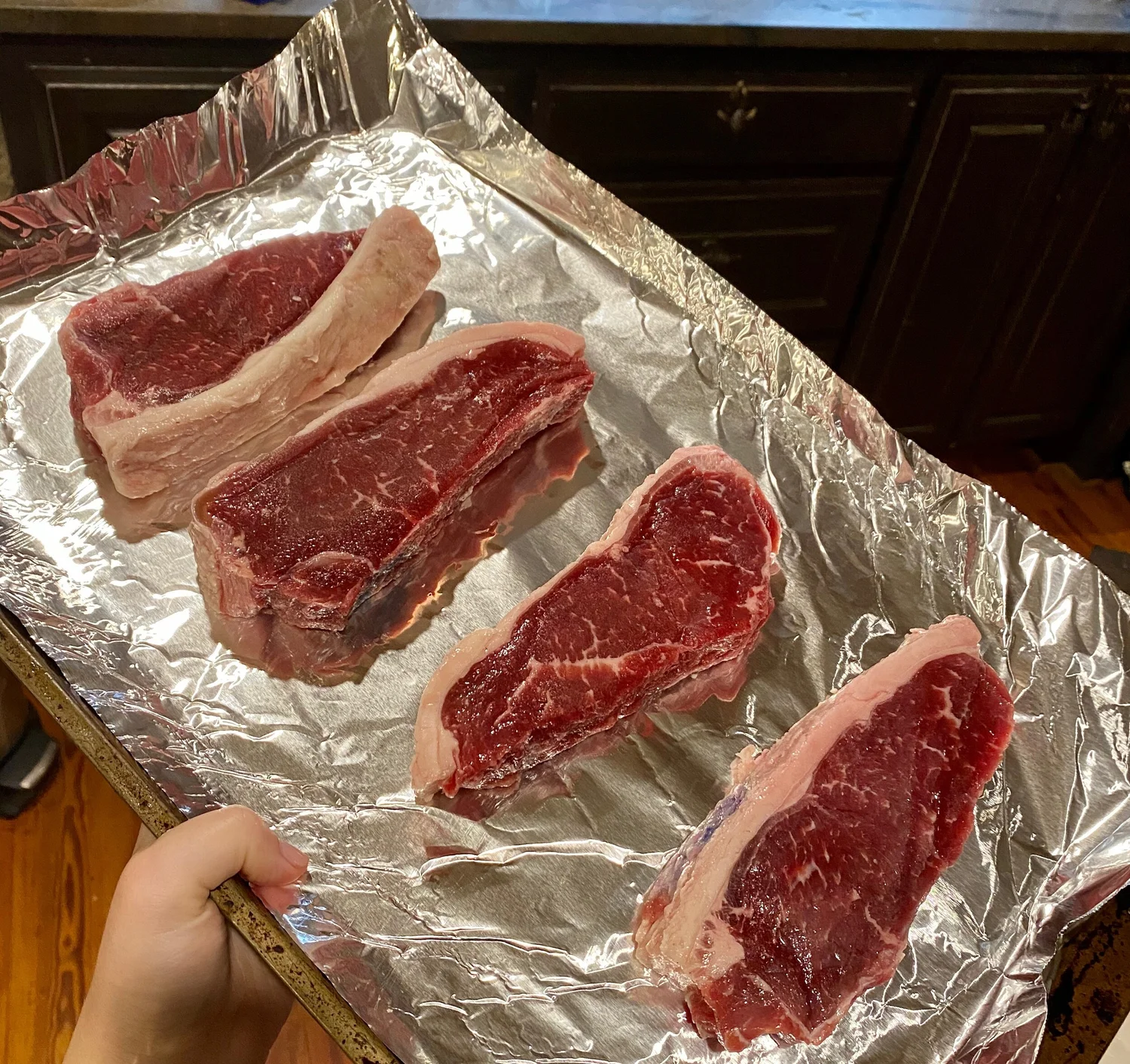 Raw Neverdun steaks on a foil-lined tray